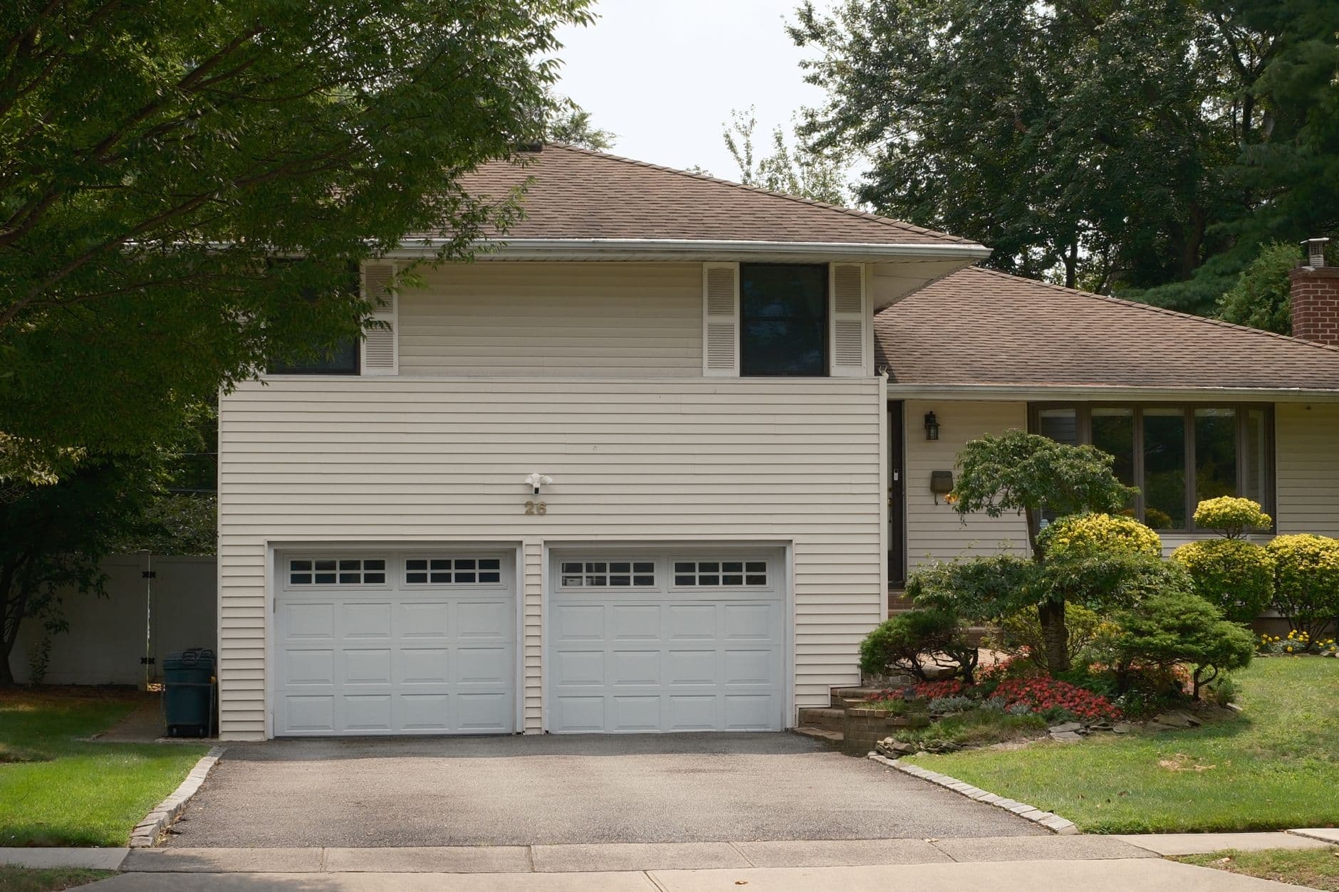 Charming suburban house featuring a double garage and lush garden, ideal for real estate listings.